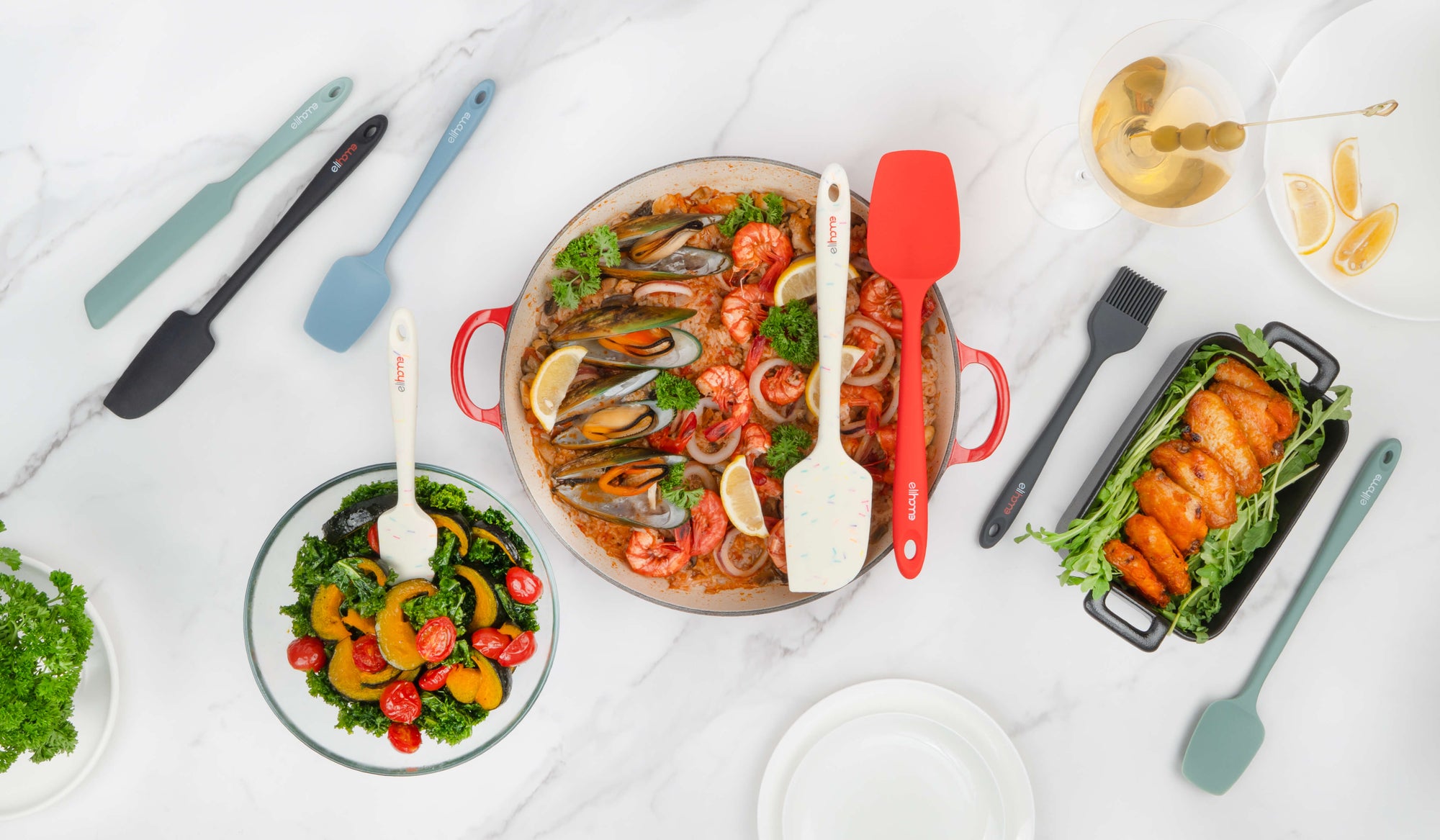 Elihome silicone kitchen utensils including spatulas, spoons, and brushes displayed with gourmet dishes on marble countertop