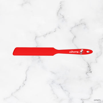 Red spatula with 'elithe' branding on a white marble background