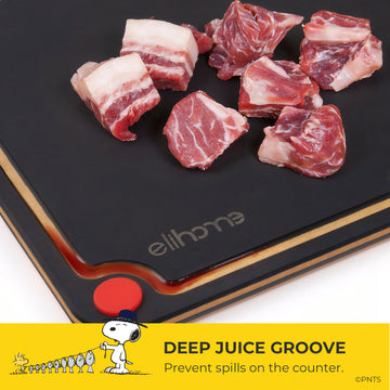 Raw meat on a black cutting board with 'elihome' branding, featuring a deep juice groove.
