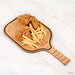 Wooden paddle with fried chicken and fries on a white background