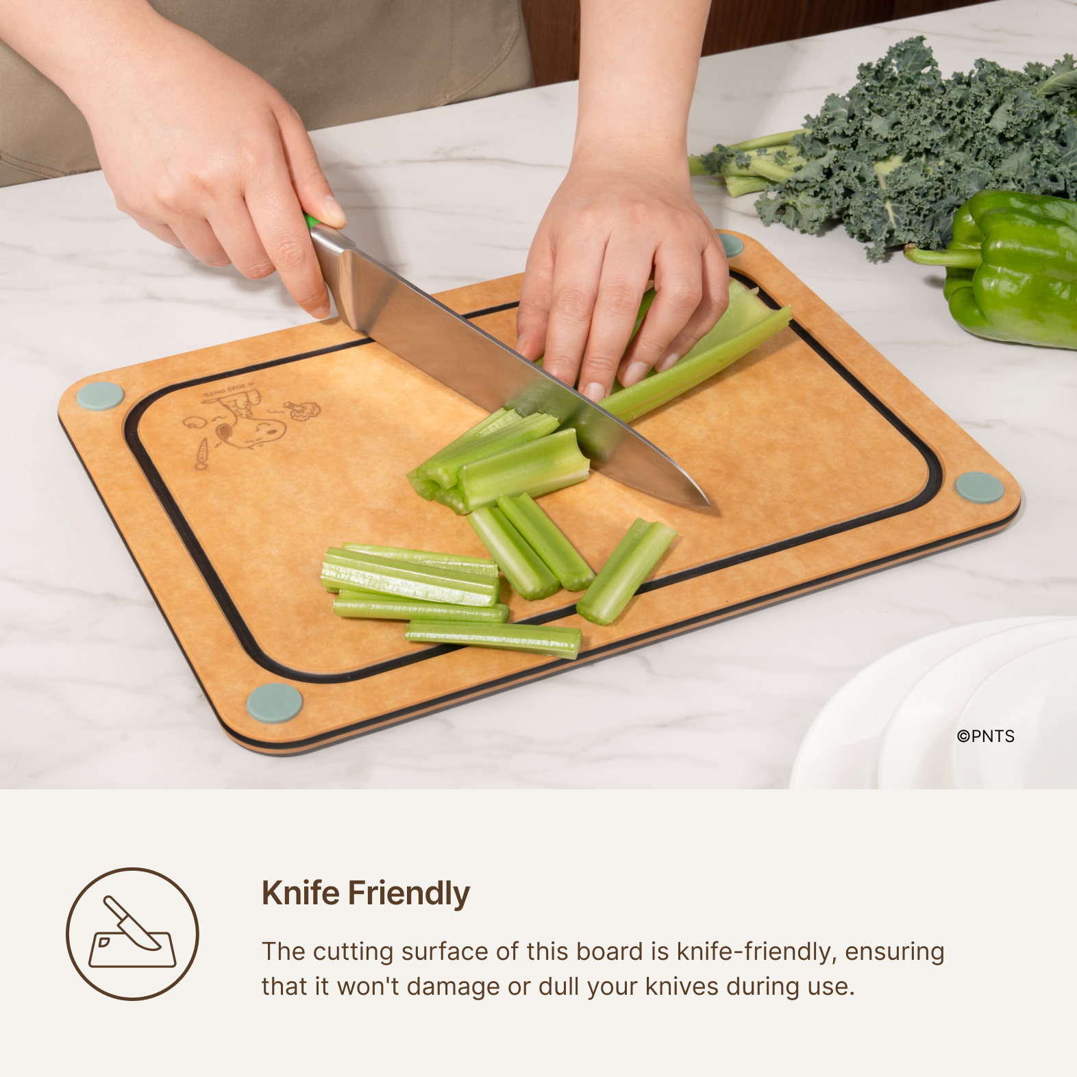 Knife slicing celery on the Elihome x Peanuts 4-in-1 cutting board, knife-friendly surface that will not dull your knives