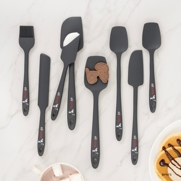 Elihome x Peanuts silicone spatulas, spoonulas, spreader and basting brush in Grey with Snoopy artwork on a marble counter beside cookies and chocolate sauce