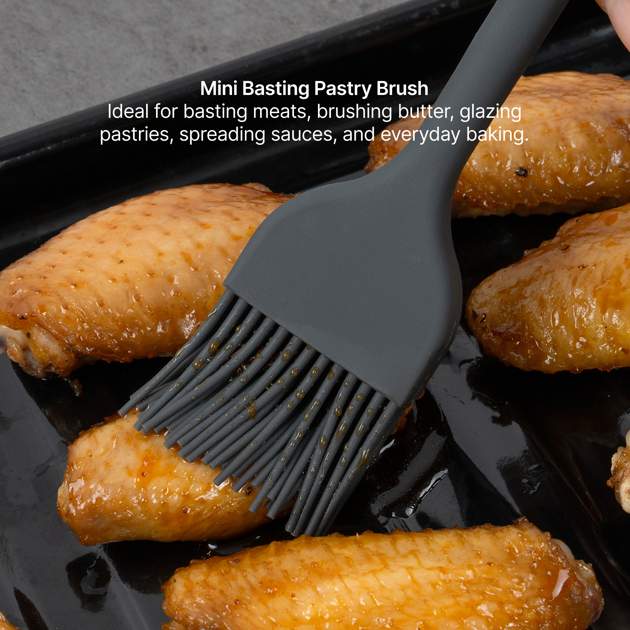 Elihome x Peanuts Mini Basting Pastry Brush from the 8 piece set glazing baked chicken wings on a sheet pan