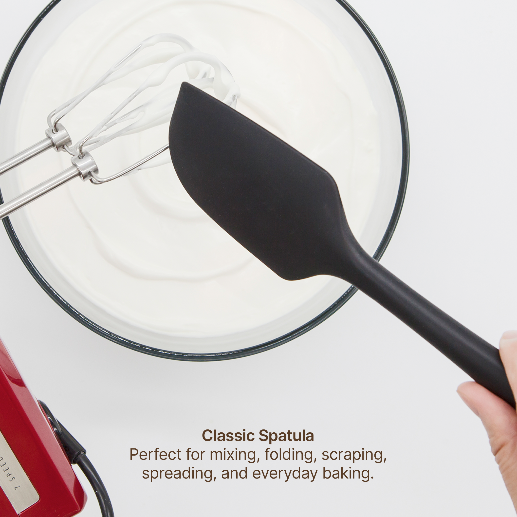Hand using the Elihome x Peanuts Classic Spatula to fold whipped cream in a mixing bowl, perfect for mixing, folding, scraping, spreading and everyday baking